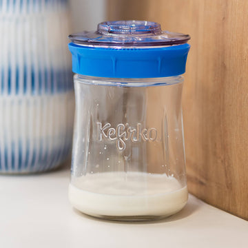 Tarro de vidrio Kefirko con tapa azul, cerrado y listo para fermentar leche con los nódulos de kéfir en su interior.