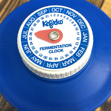 Primer plano de la tapa con el reloj de fermentación Kefirko, que muestra los meses y los días.